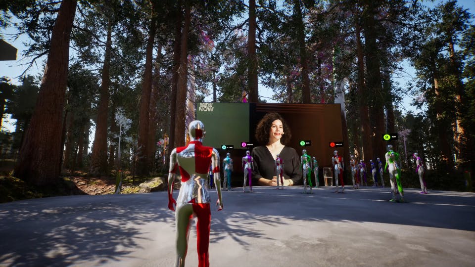 Eine computergenerierte Szene in einem virtuellen Wald, in der futuristische, metallisch glänzende Avatare einem großen Bildschirm gegenüberstehen. Auf dem Bildschirm ist eine Frau mit lockigem Haar und schwarzem Oberteil zu sehen, die spricht. Die Umgebung ist von hohen Bäumen umgeben, durch deren Äste Sonnenlicht fällt. Die Szenerie kombiniert Natur mit digitaler Technologie und vermittelt den Eindruck eines virtuellen Treffpunkts oder einer digitalen Konferenz im Freien.
