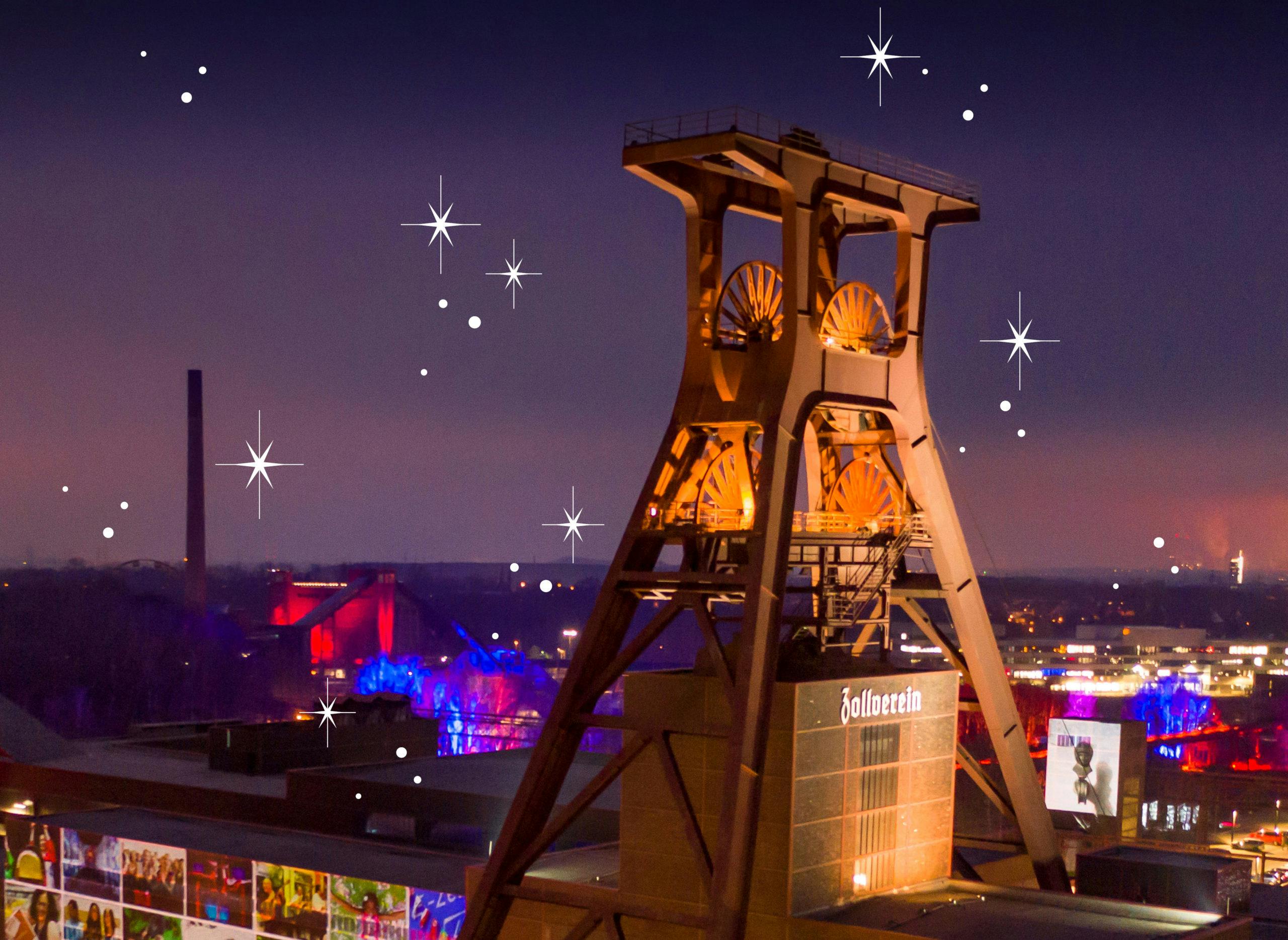 Nachtaufnahme des beleuchteten Fördergerüsts der Zeche Zollverein in Essen, einem bekannten Industriedenkmal. Das Gerüst ist in warmem Licht angestrahlt und hebt sich vom dunklen Himmel ab. Im Hintergrund sind bunte Lichtinstallationen in Blau, Rot und Violett zu sehen. Weiße grafische Sterne und Punkte sind über das Bild verteilt und erzeugen eine festliche, märchenhafte Atmosphäre.