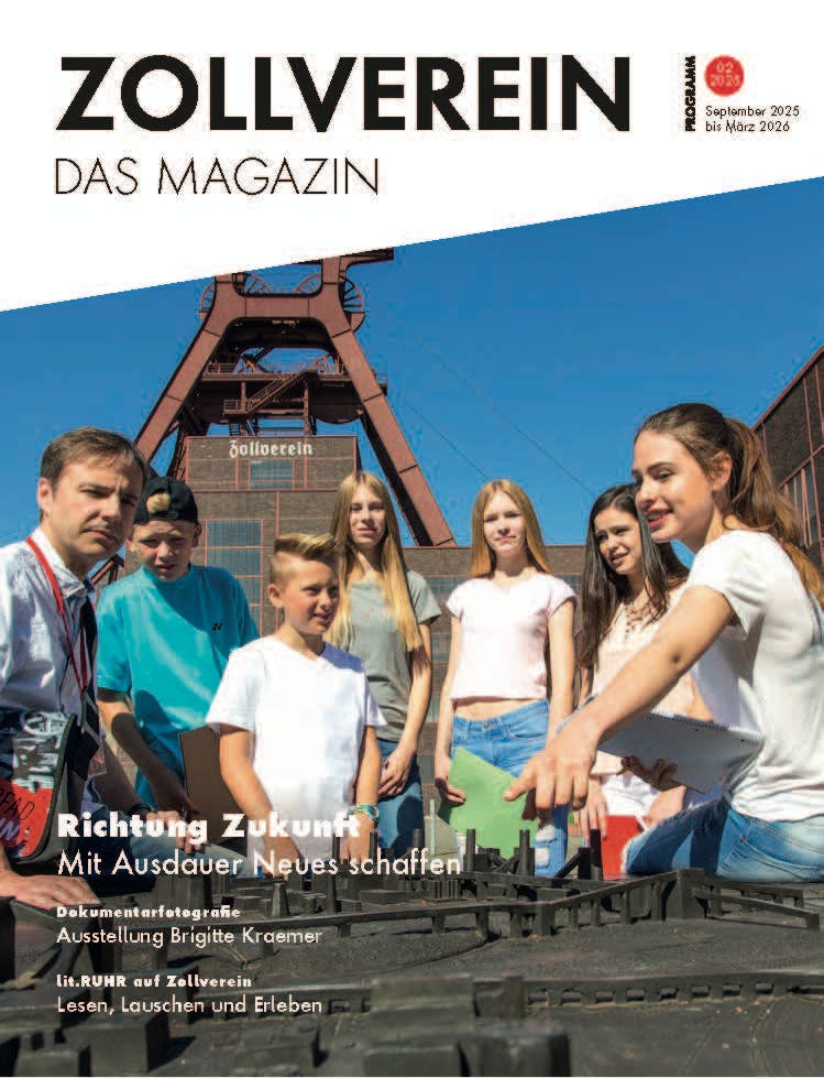 Titelblatt des Zollverein Magazins für den Zeitraum September 2025 bis März 2026. Im Hintergrund ist das markante Fördergerüst der Zeche Zollverein zu sehen, davor eine Gruppe von Jugendlichen und einem Erwachsenen, die sich um ein Modell versammelt haben. Der Titel lautet Richtung Zukunft – Mit Ausdauer Neues schaffen. Weitere Themen sind eine Ausstellung mit Dokumentarfotografie von Brigitte Kraemer sowie lit.RUHR auf Zollverein mit Lesen, Lauschen und Erleben.