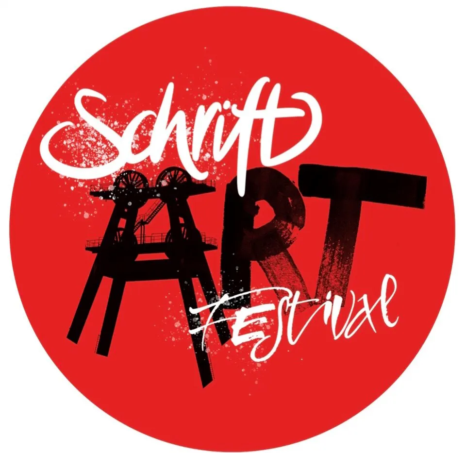 Rundes rotes Logo für ein SchriftART Festival. In weißer, dynamischer Schreibschrift steht oben Schrift und unten Festival. In der Mitte dominiert das große schwarze Wort ART, wobei der Buchstabe A mit der Silhouette eines Fördergerüsts kombiniert ist. Weiße Farbspritzer und Pinselstrukturen verstärken den künstlerischen Charakter des Motivs.