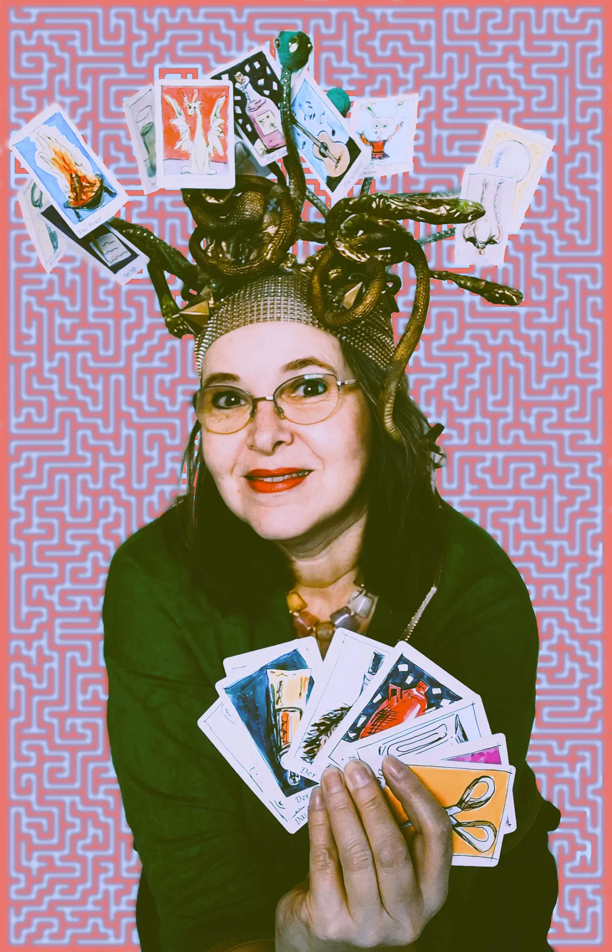 Eine Person hält mehrere Tarotkarten fächerförmig in der Hand. Auf dem Kopf trägt sie eine auffällige Kopfbedeckung, die an Schlangenhaare erinnert und mit weiteren Tarotkarten geschmückt ist. Der Hintergrund zeigt ein labyrinthisches Muster in Rosa und Hellblau.