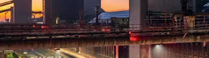 Plakat für das Jahr 2026 mit dem Titel 2026 Highlights und Programm. Oben rechts steht Oktober November Dezember. Im Hintergrund ist das UNESCO-Welterbe Zollverein bei Dämmerung zu sehen. Im Vordergrund findet auf einer langen, beleuchteten Eisfläche eine große Veranstaltung mit zahlreichen Schlittschuhläuferinnen und Schlittschuhläufern statt. Unten steht 25 Jahre UNESCO Welterbe Zollverein.